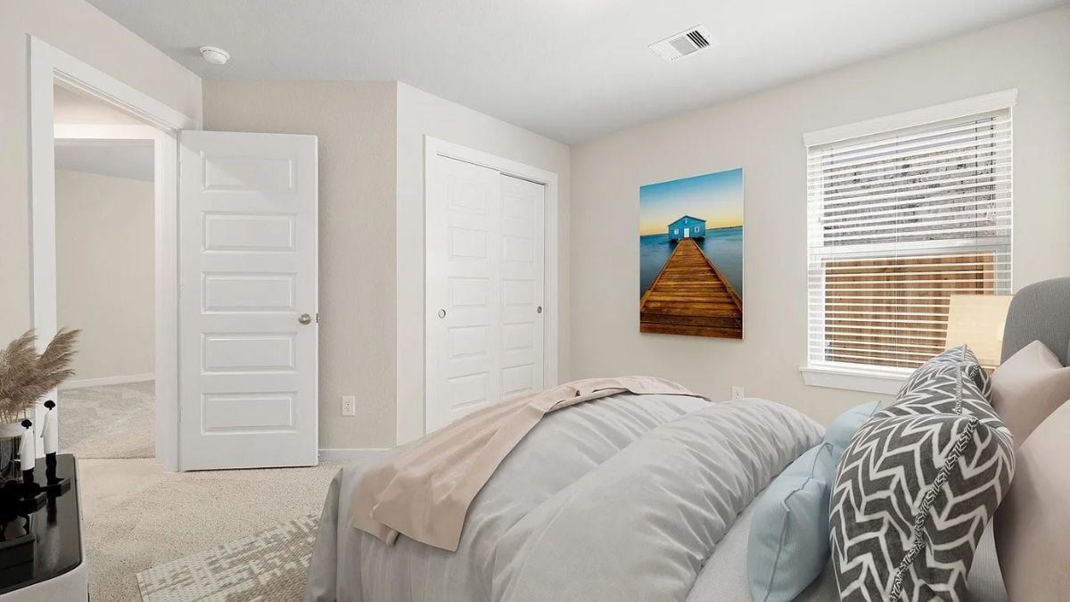 A bedroom with a bed, a window, and a painting.