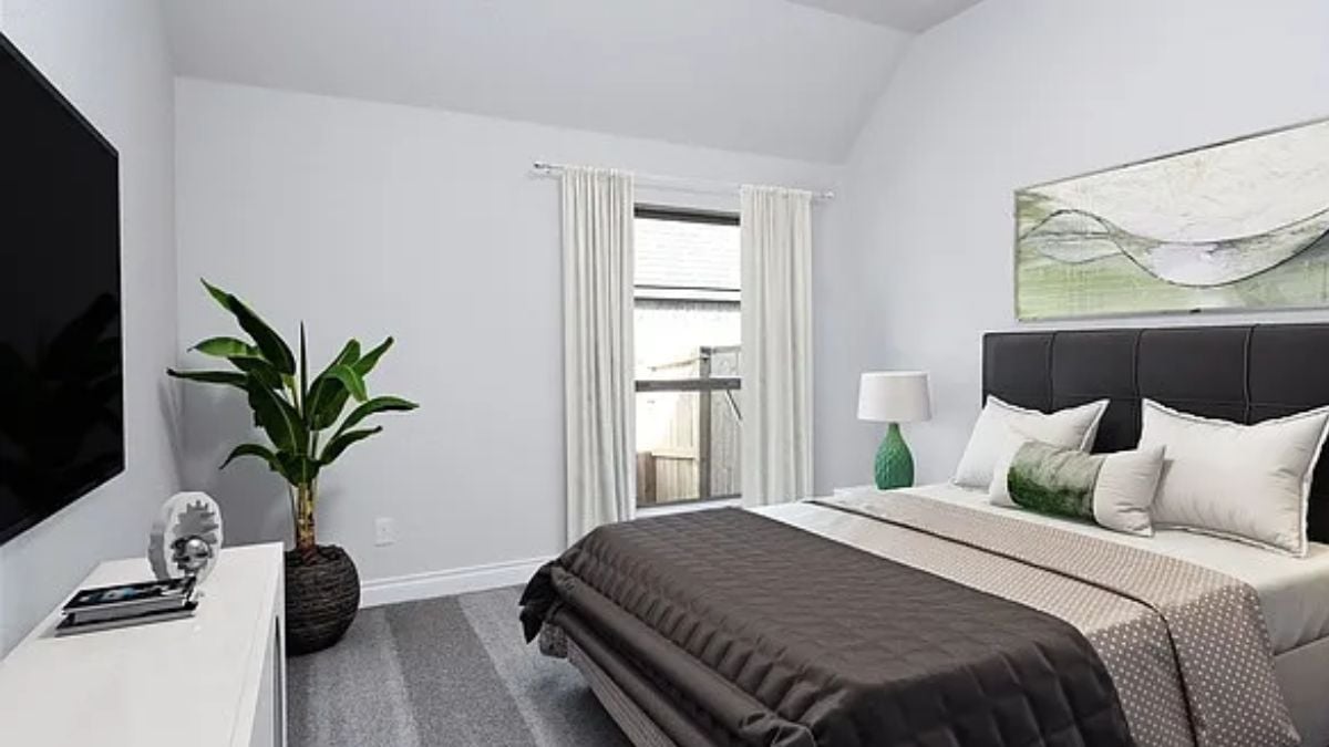 A bedroom with a window, a bed, a painting, a TV, and a cabinet.