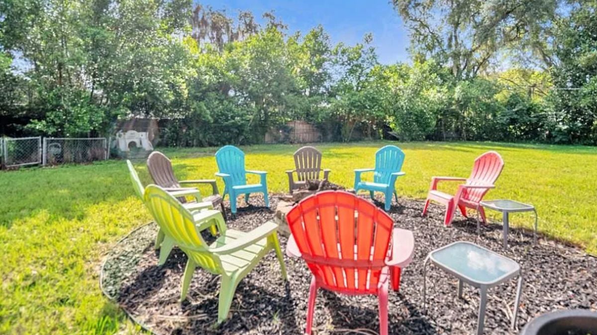 A patio with a table surrounded by chairs.