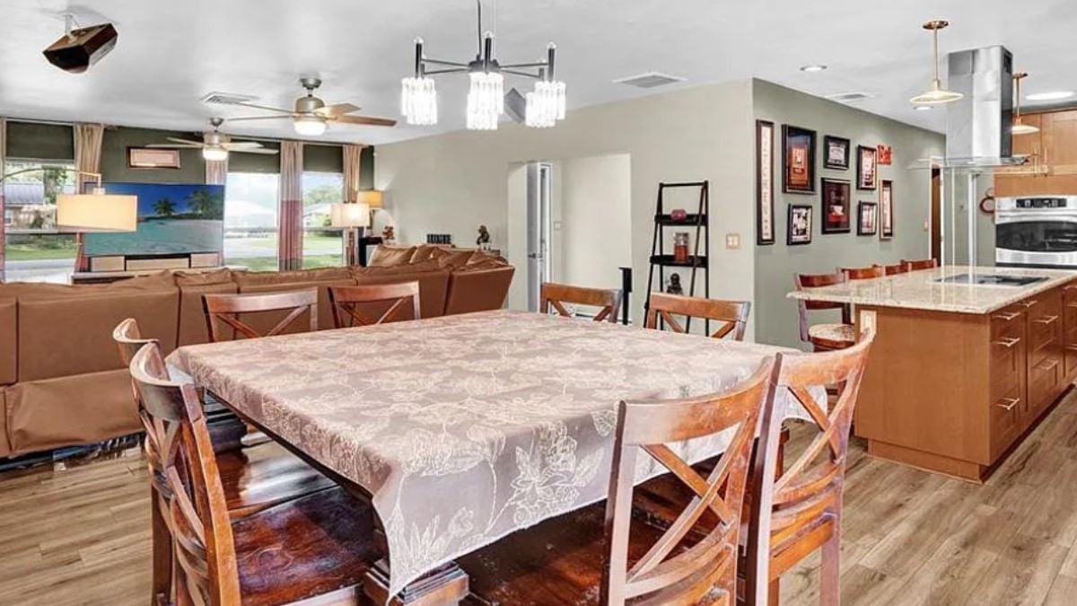 A great room with a dining area, living area, and kitchen.