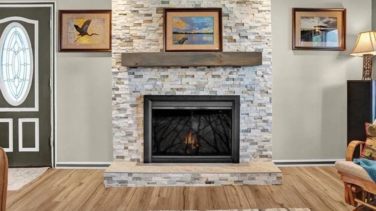 A living room with paintings and a fireplace.