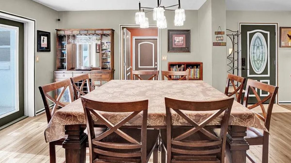 A dining room with a dining table surrounded by chairs.