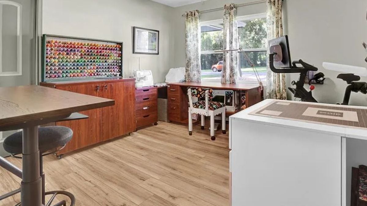 A home office with a window, a cabinet, a table, a desk, and chairs.