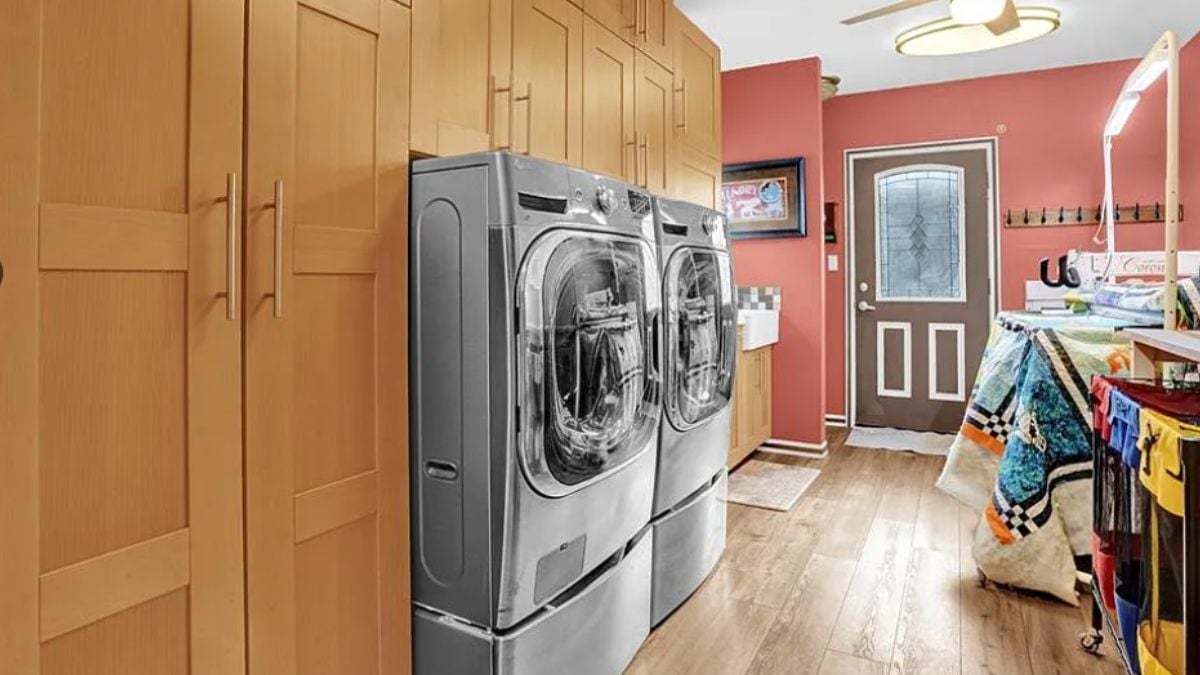 A laundry room with washing machines and cabinets.