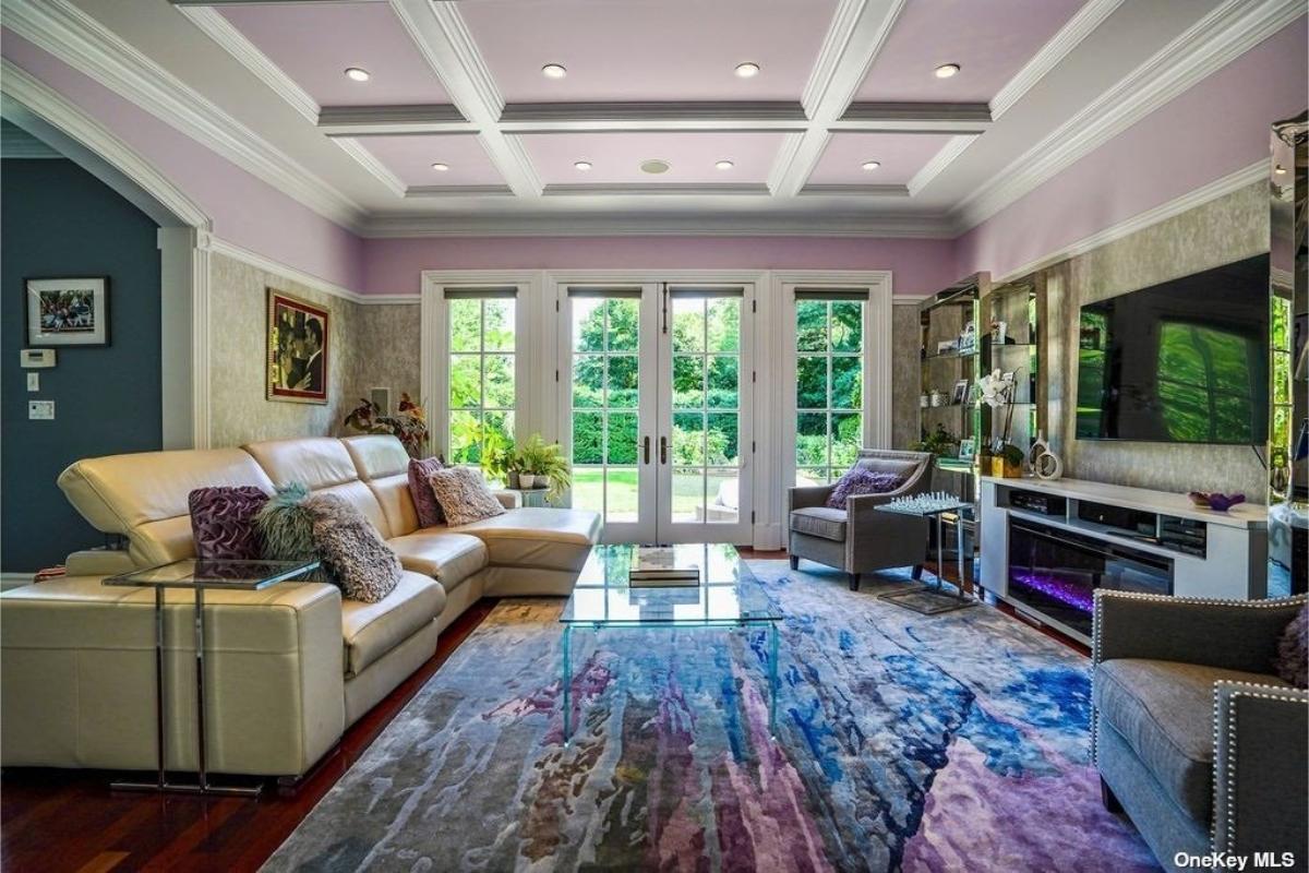 Living room with couches and hardwood flooring.