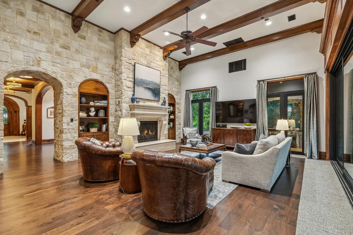 Living room with couches, hardwood floors and a fireplace.