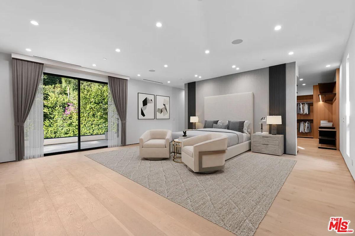 Bedroom with a large bed, sliding glass doors and hardwood floors.