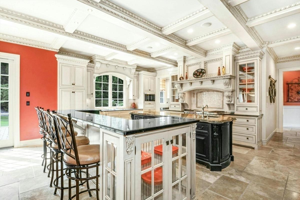 Kitchen with custom cabinetry, a counter breakfast bar and a center island prep area.