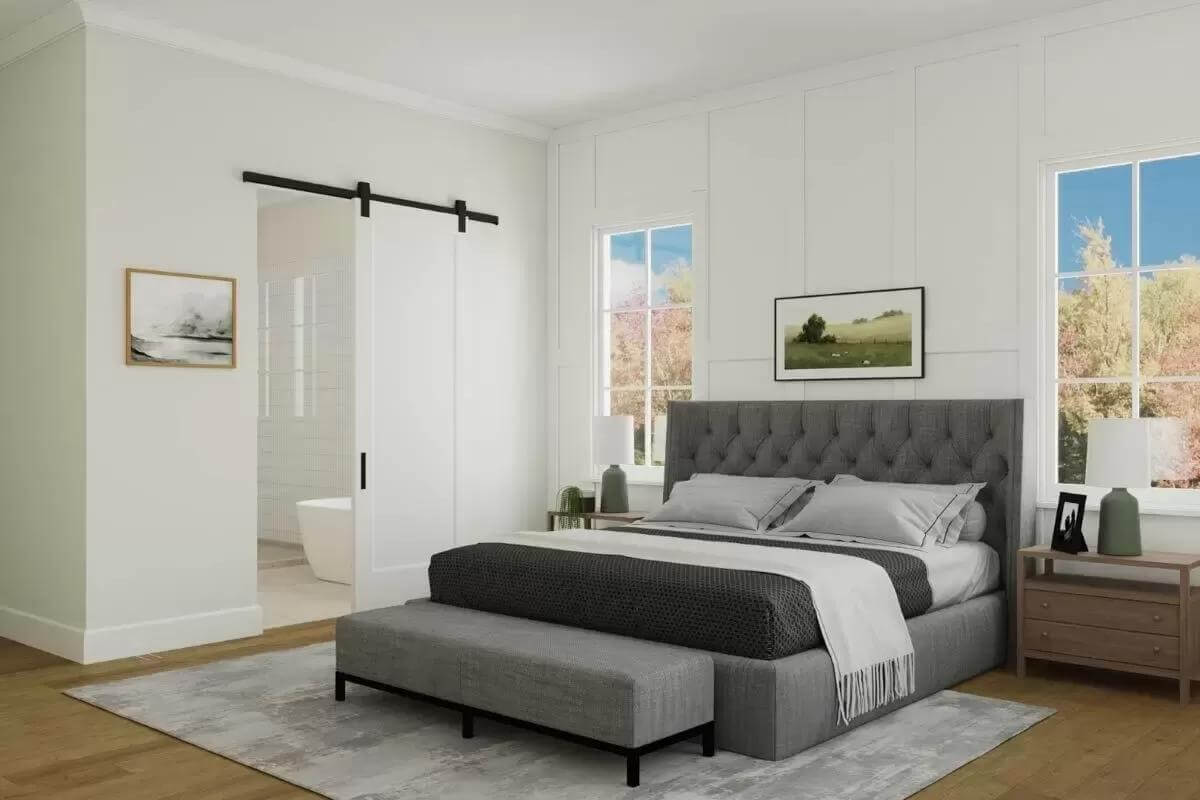 Primary bedroom with a tufted bed and a cushioned bench over the distressed area rug.