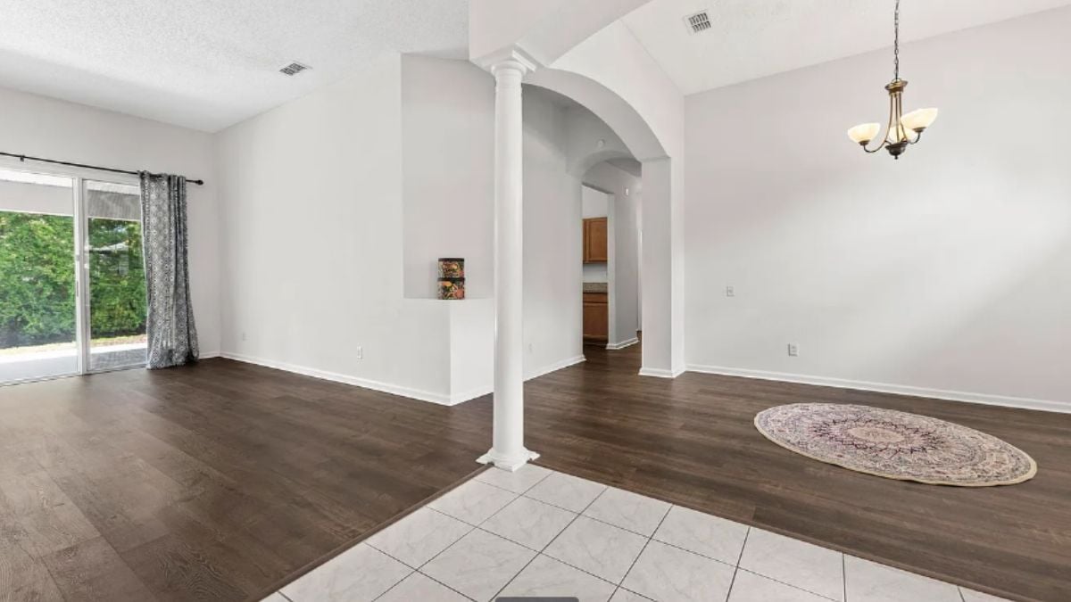 A foyer with columns and a chandelier.