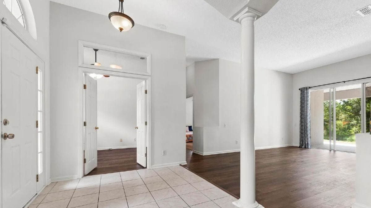 A foyer with columns and a chandelier.