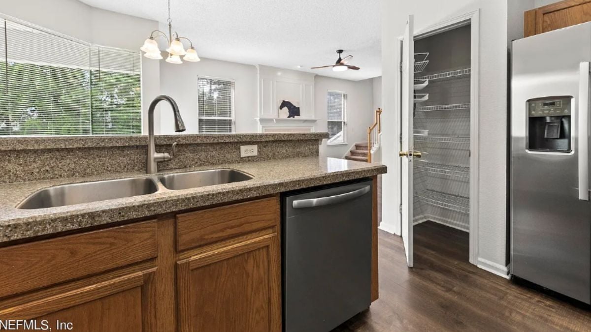A kitchen with countertops, cabinets, a sink, and kitchen appliances.