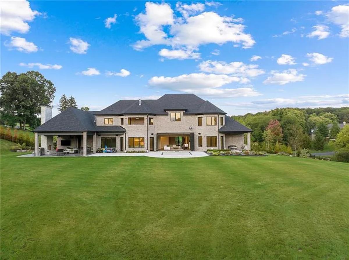 Rear view of the mansion with a large green lawn.