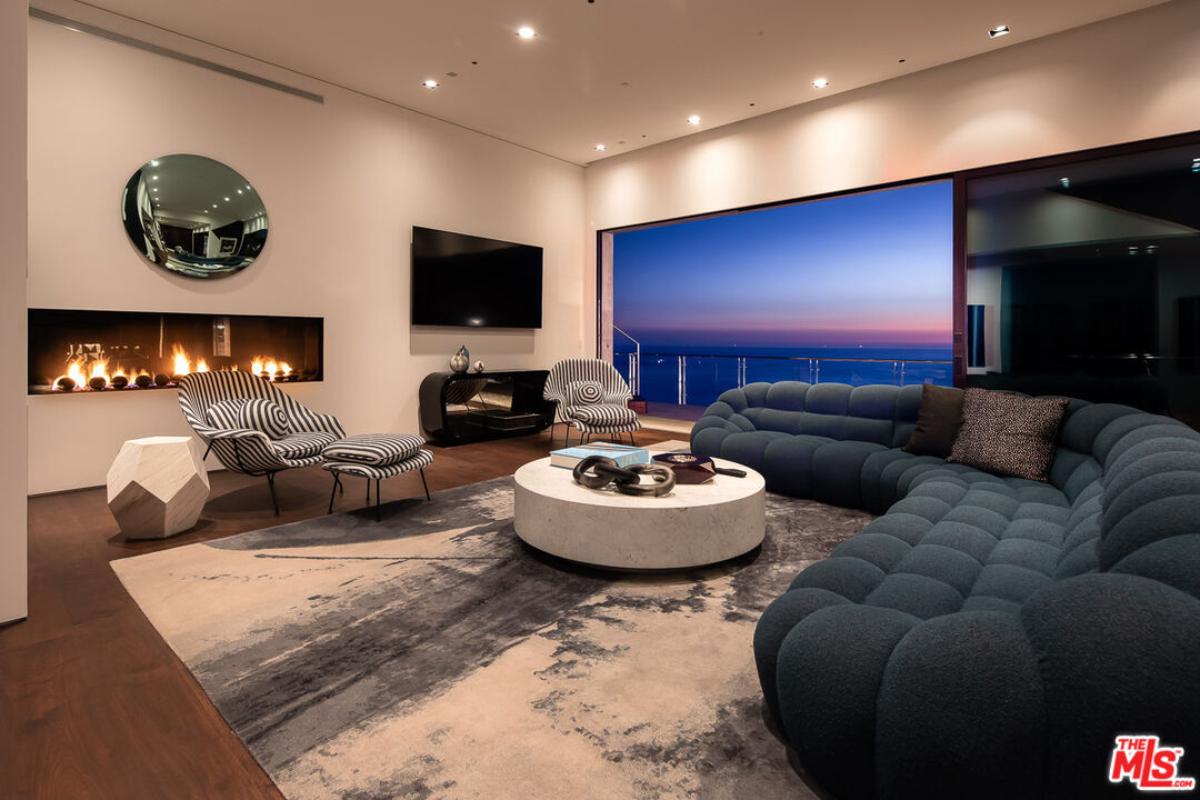 Living room with hardwood floors, a fireplace and sliding glass doors.