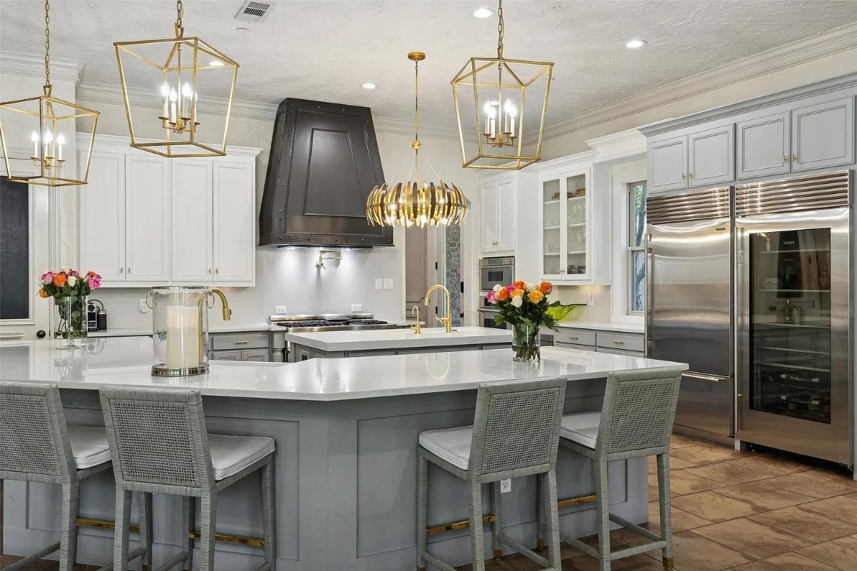 Kitchen with custom cabinetry, stainless-steel appliances, a counter breakfast bar and a center island prep area.