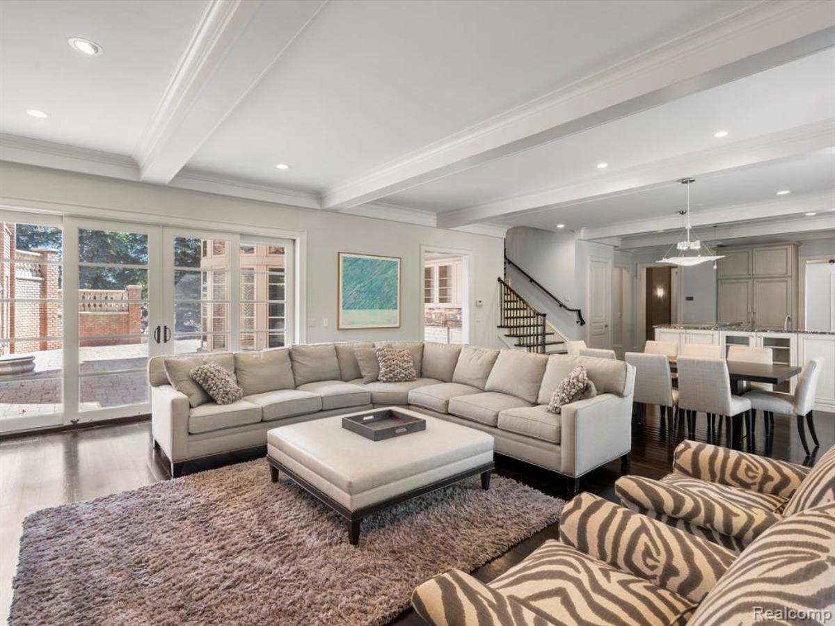 Living room with couches and hardwood flooring.