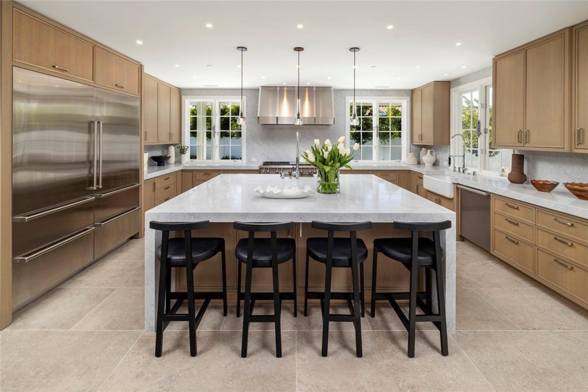 Kitchen with custom cabinetry, a counter breakfast bar and stainless-steel appliances.