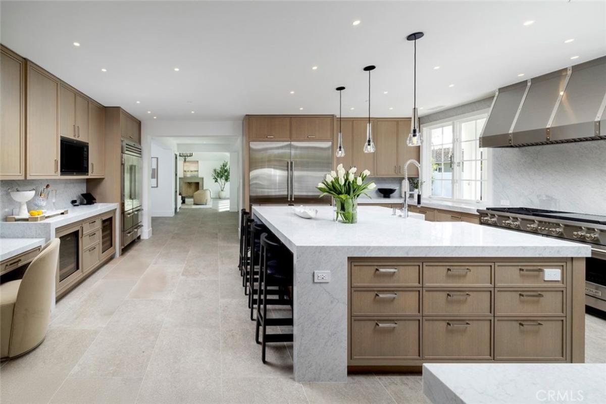 Kitchen with custom cabinetry, a counter breakfast bar and stainless-steel appliances.