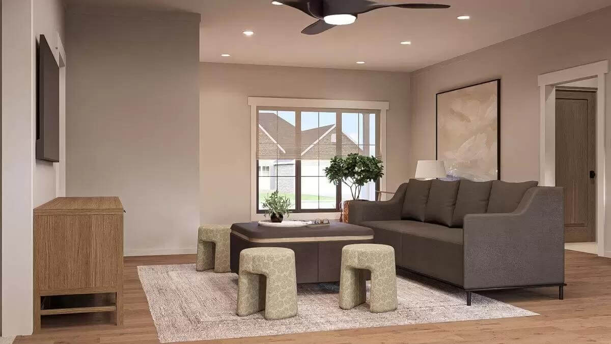 Family room with a brown sofa, round chairs and a wall-mounted TV.
