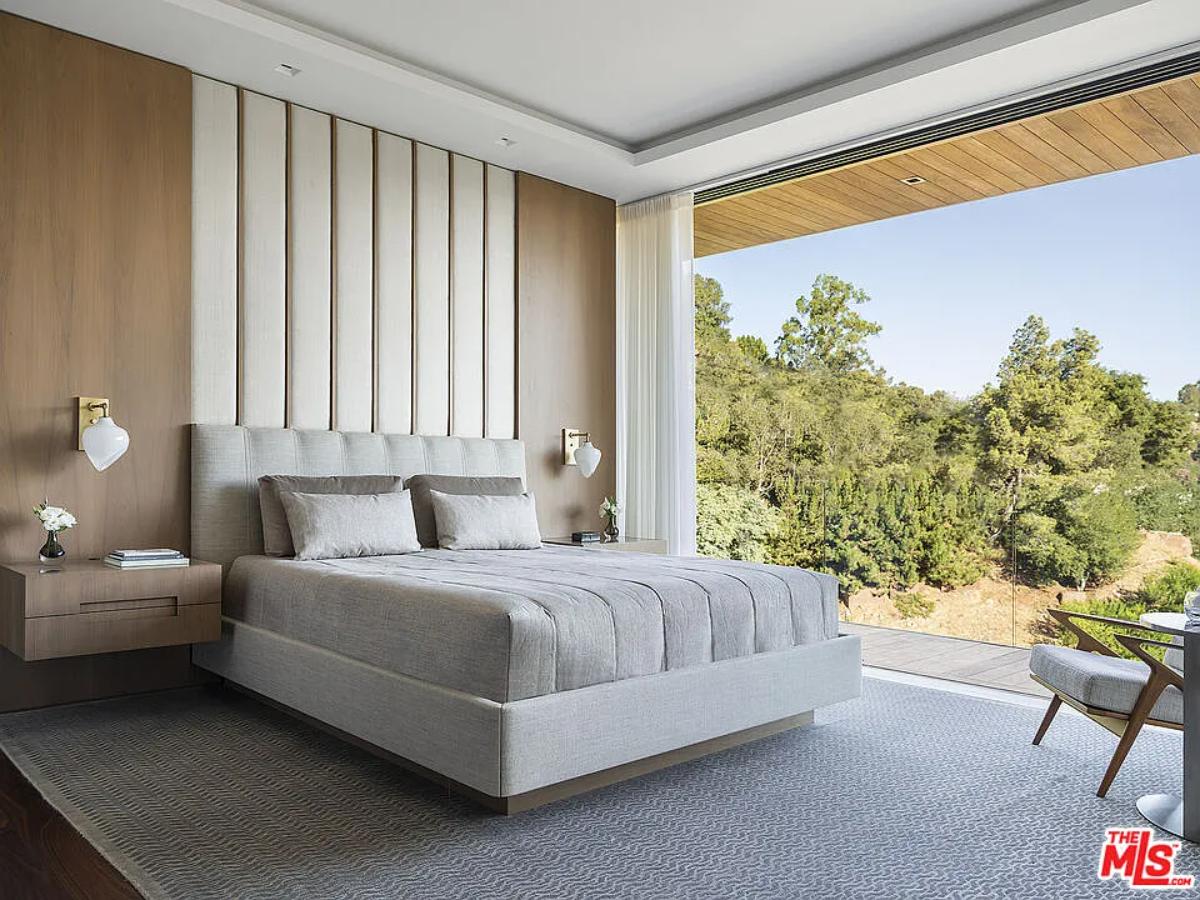 Bedroom with a large bed and glass walls.