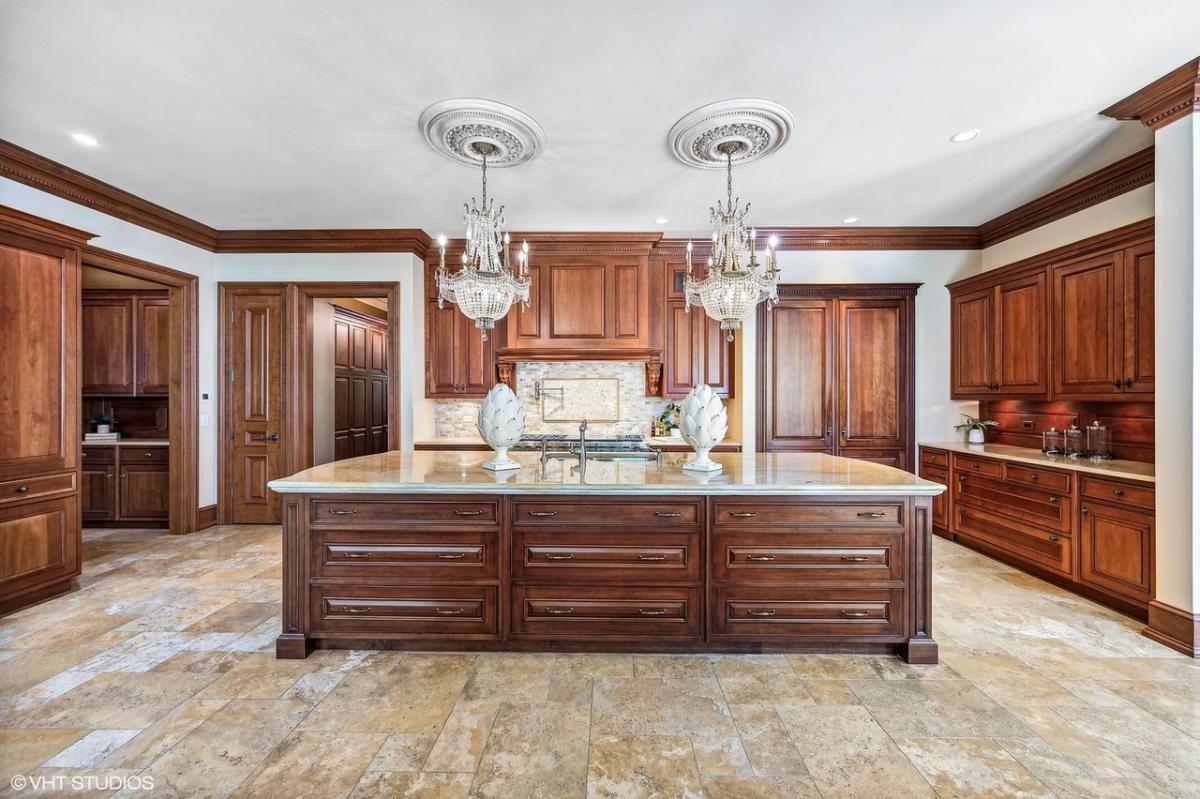 Kitchen with chandeliers and custom cabinetry.