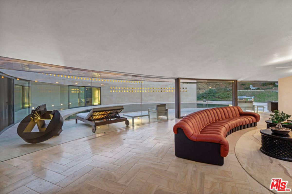 Living room with a couch and glass walls.
