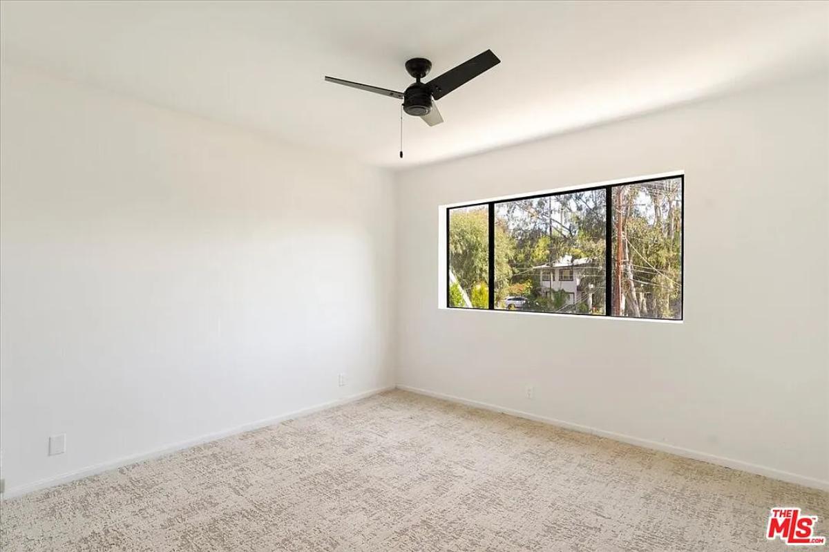 Bedroom with glass windows and carpet flooring.