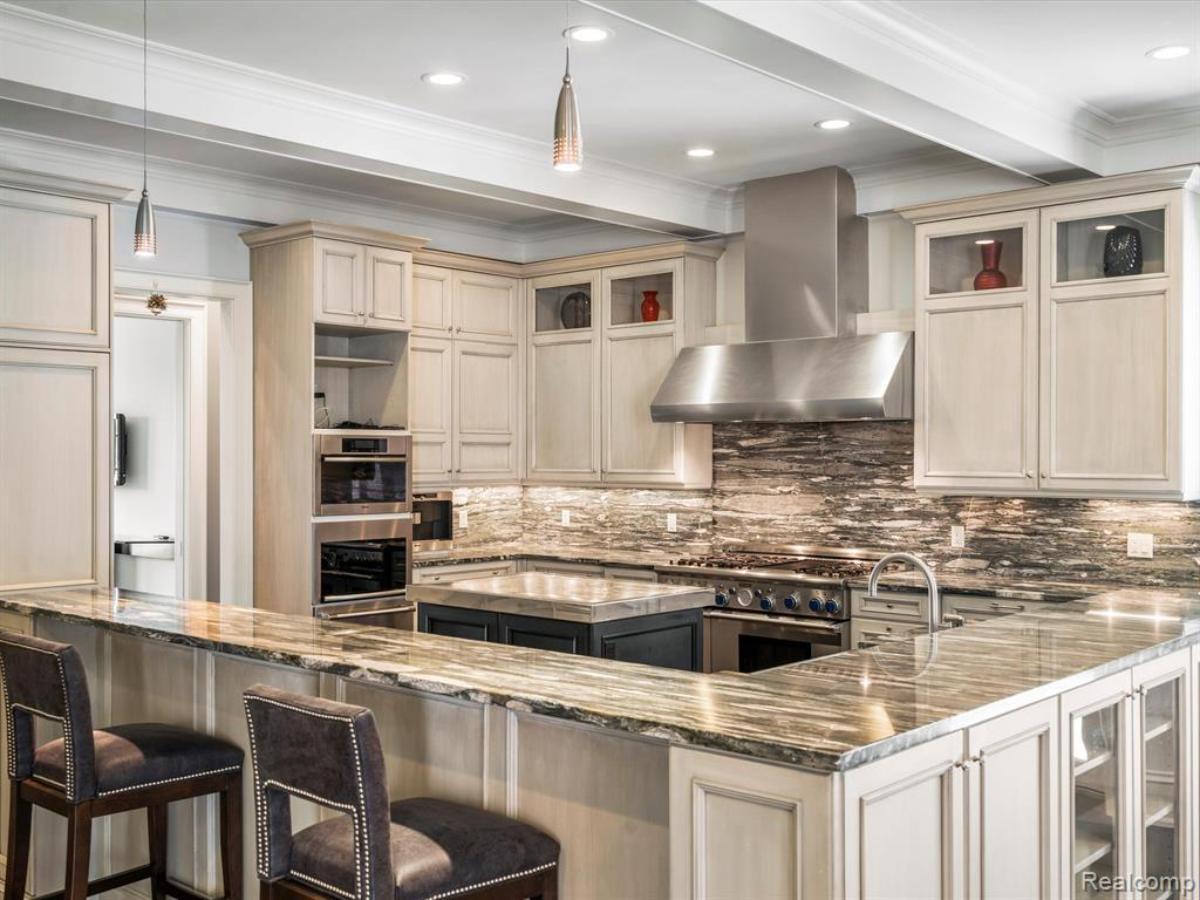 Kitchen with custom cabinetry, a counter breakfast bar and a center island prep area.