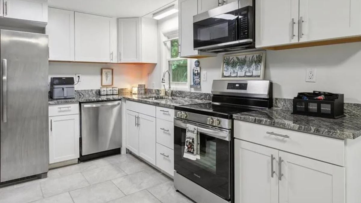 A kitchen with a countertop, cabinets, a sink, and kitchen appliances.