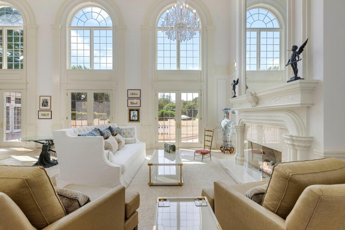Living room with high ceilings, a chandelier and a fireplace.