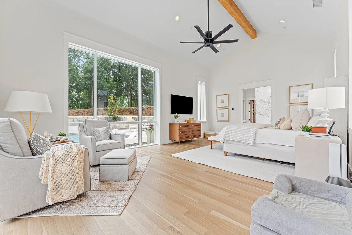 Bedroom with hardwood floors, couches and glass walls.