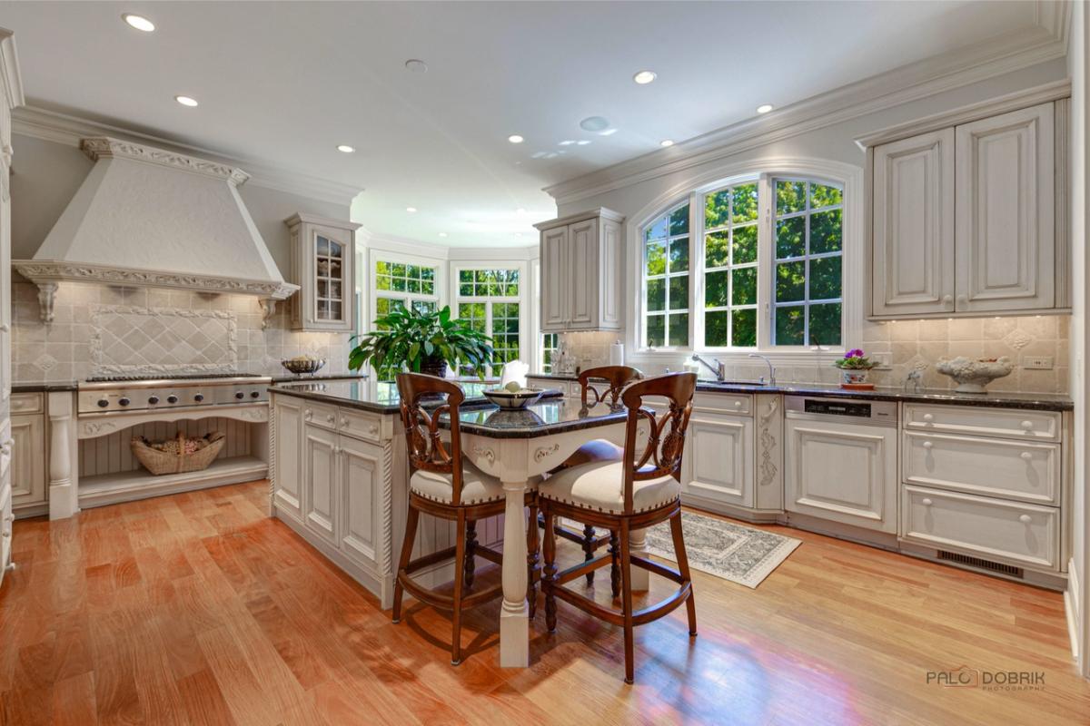 Kitchen with custom cabinetry, a counter breakfast bar and a center island prep area.