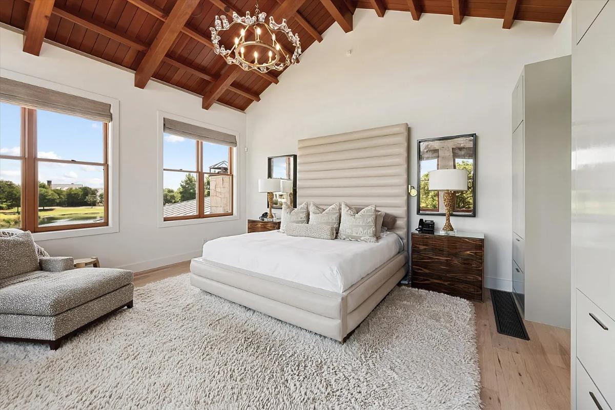 Bedroom with a large bed, a large rug and hardwood floors.