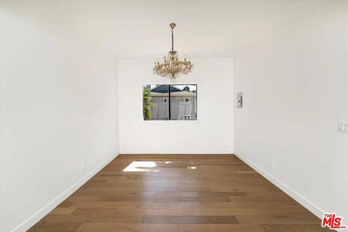 Bedroom with a chandelier and hardwood floors.