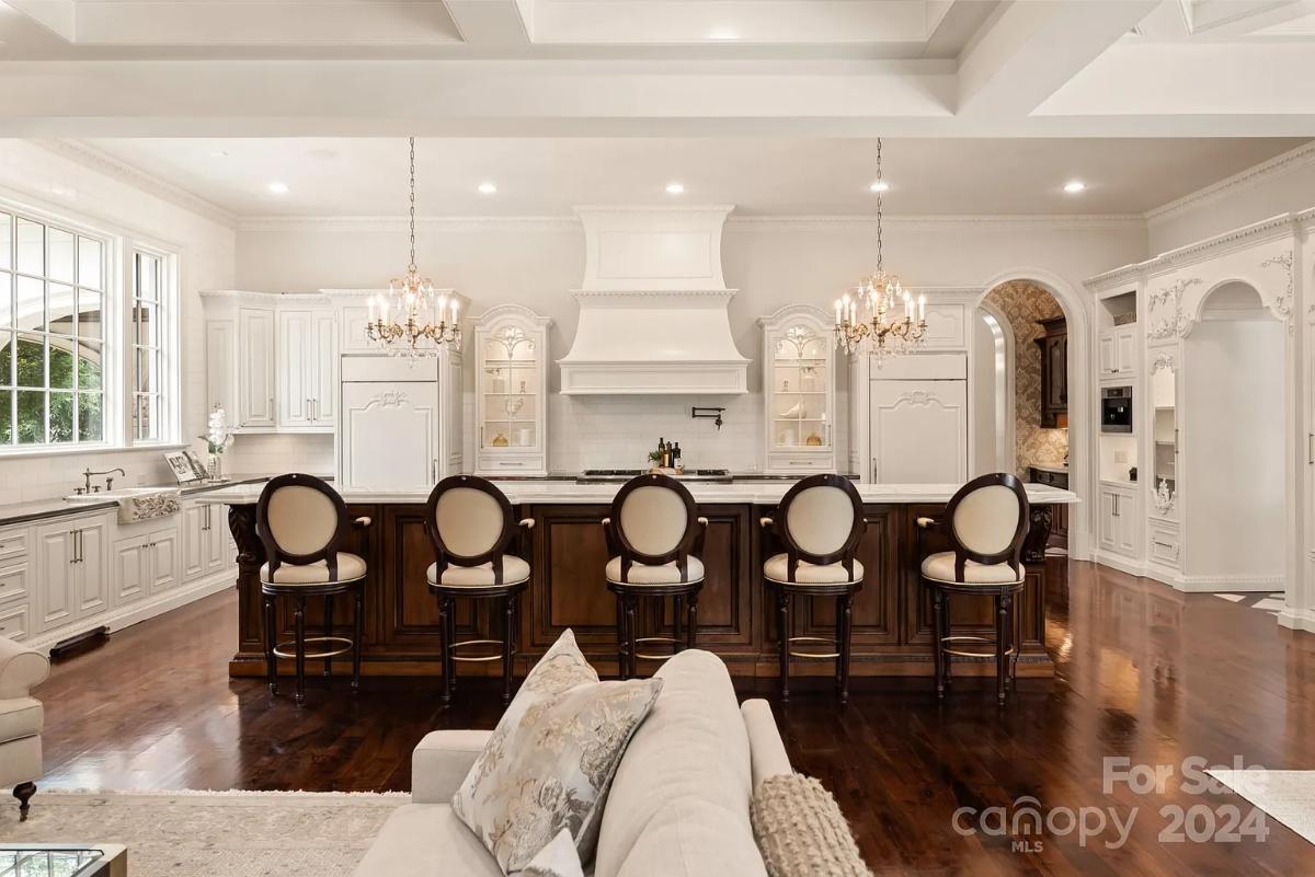 Kitchen with custom cabinetry, a counter breakfast bar and chandeliers.