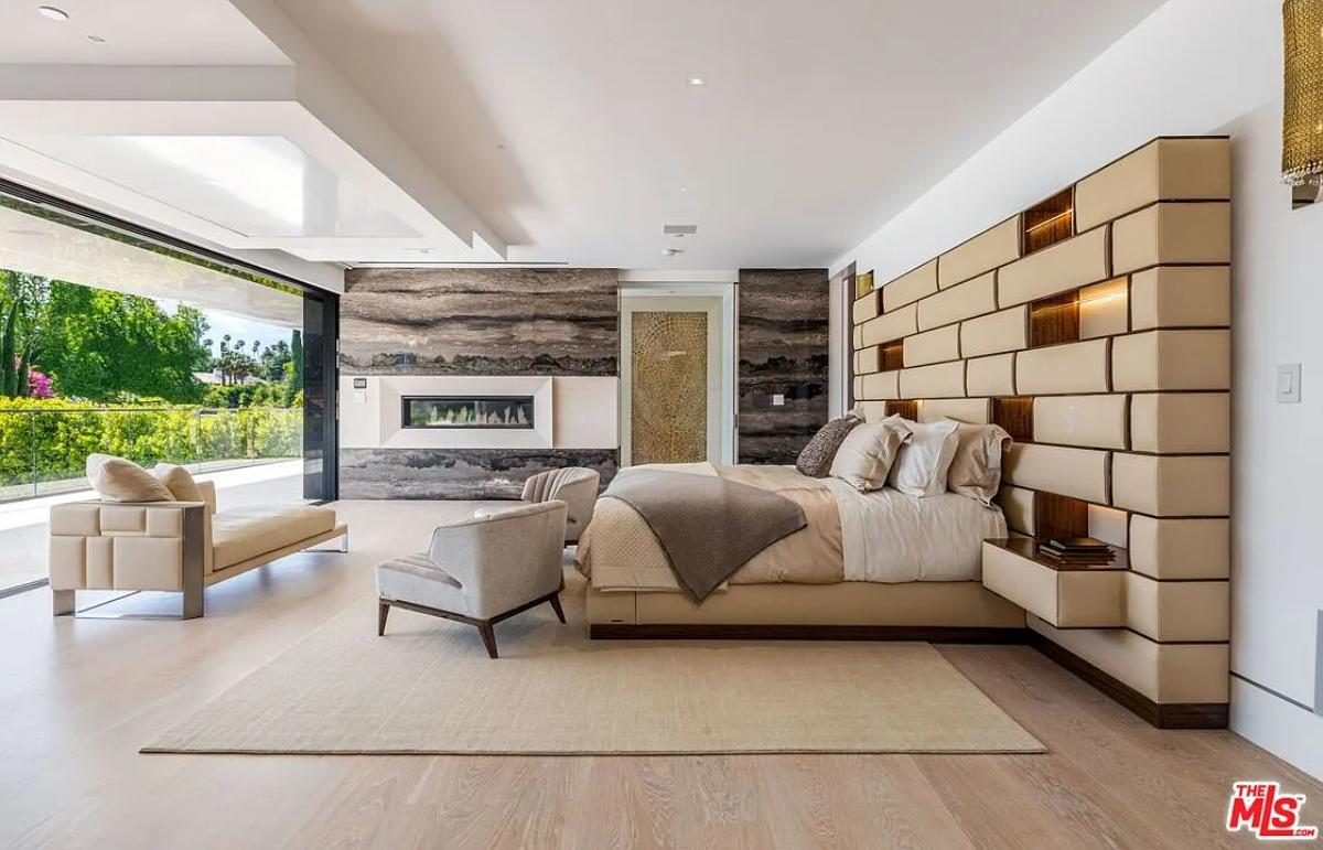 Bedroom with a large bed and a fireplace.