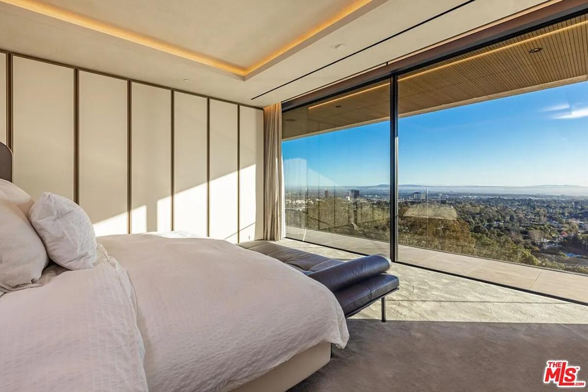 Bedroom with large sliding glass doors and carpet flooring.