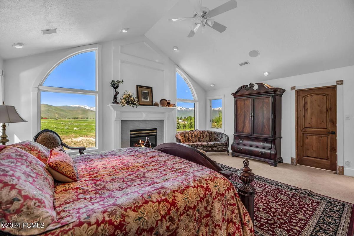 Bedroom with a large bed and a fireplace.