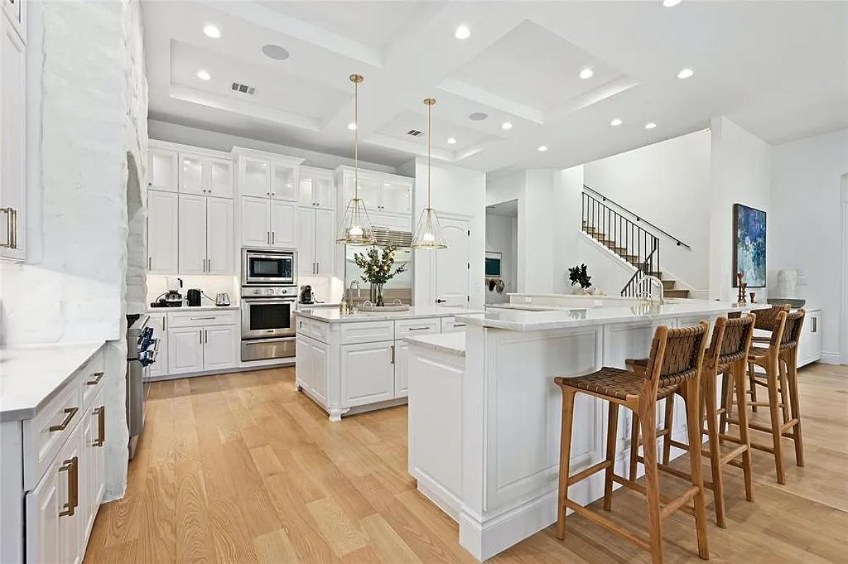 Kitchen with custom cabinetry, a counter breakfast bar and a center island prep area.