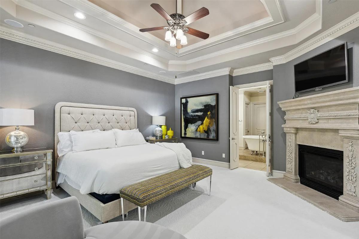 Bedroom with carpet flooring and a fireplace.