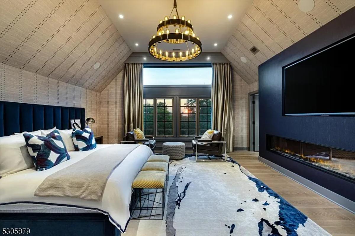 Bedroom with a chandelier and a fireplace.