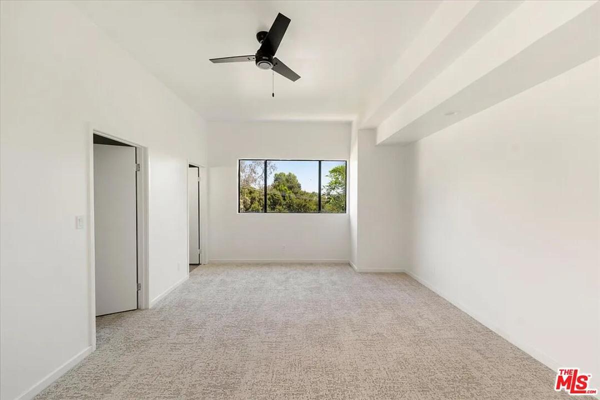 Bedroom with glass windows and carpet flooring.