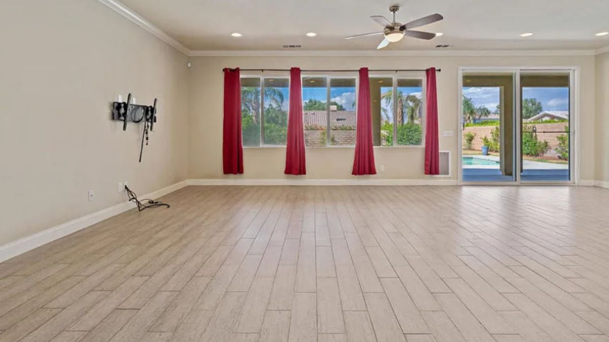 A living room with a ceiling fan and windows.