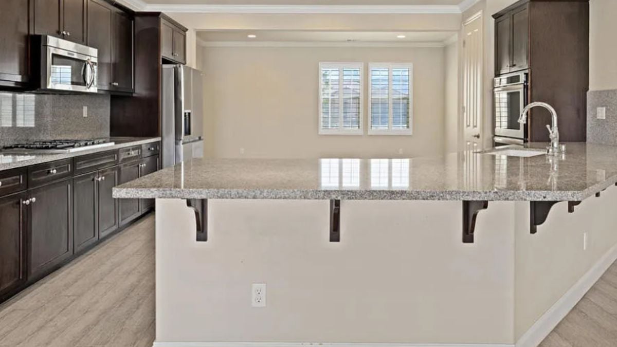 A kitchen with countertops, a sink, cabinets, and kitchen appliances.