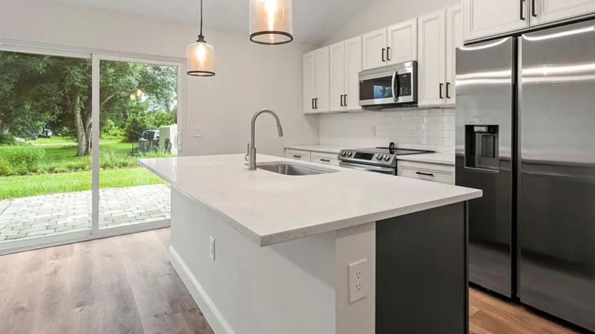 A kitchen with countertops, a sink, cabinets, and kitchen appliances.