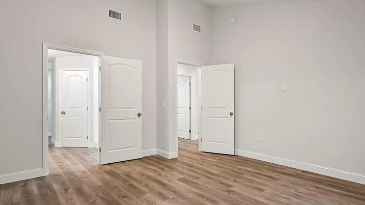 A bedroom with a wooden floor.