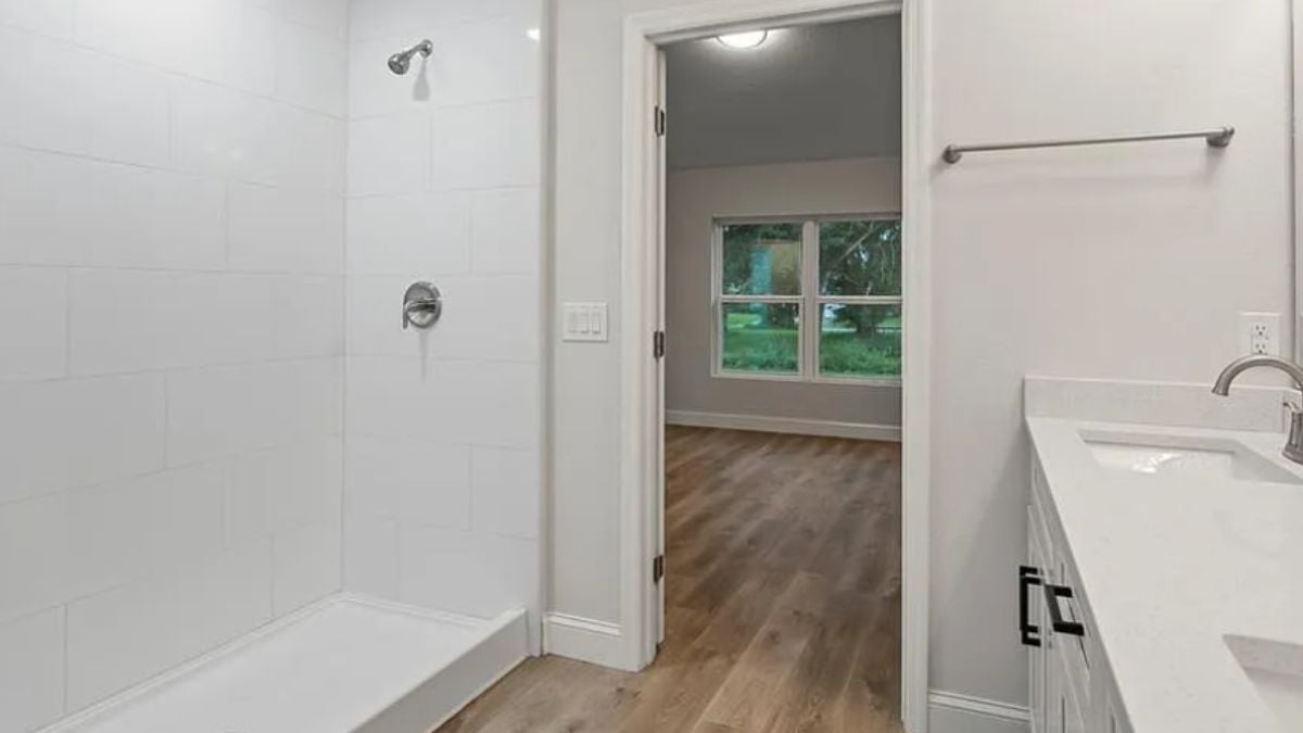 A bathroom with a vanity and a shower area.