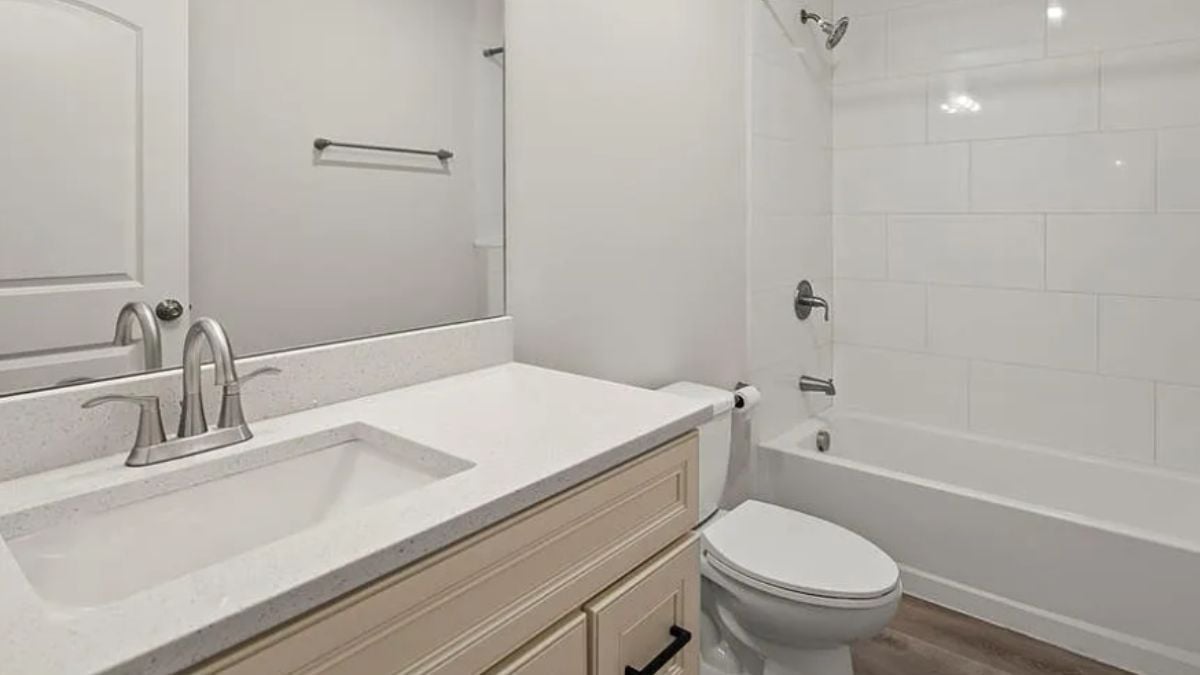 A bathroom with a vanity, a toilet, and a bathtub.