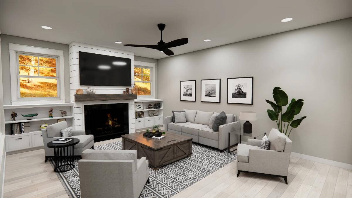 Great room with gray seats and a fireplace topped by a TV.