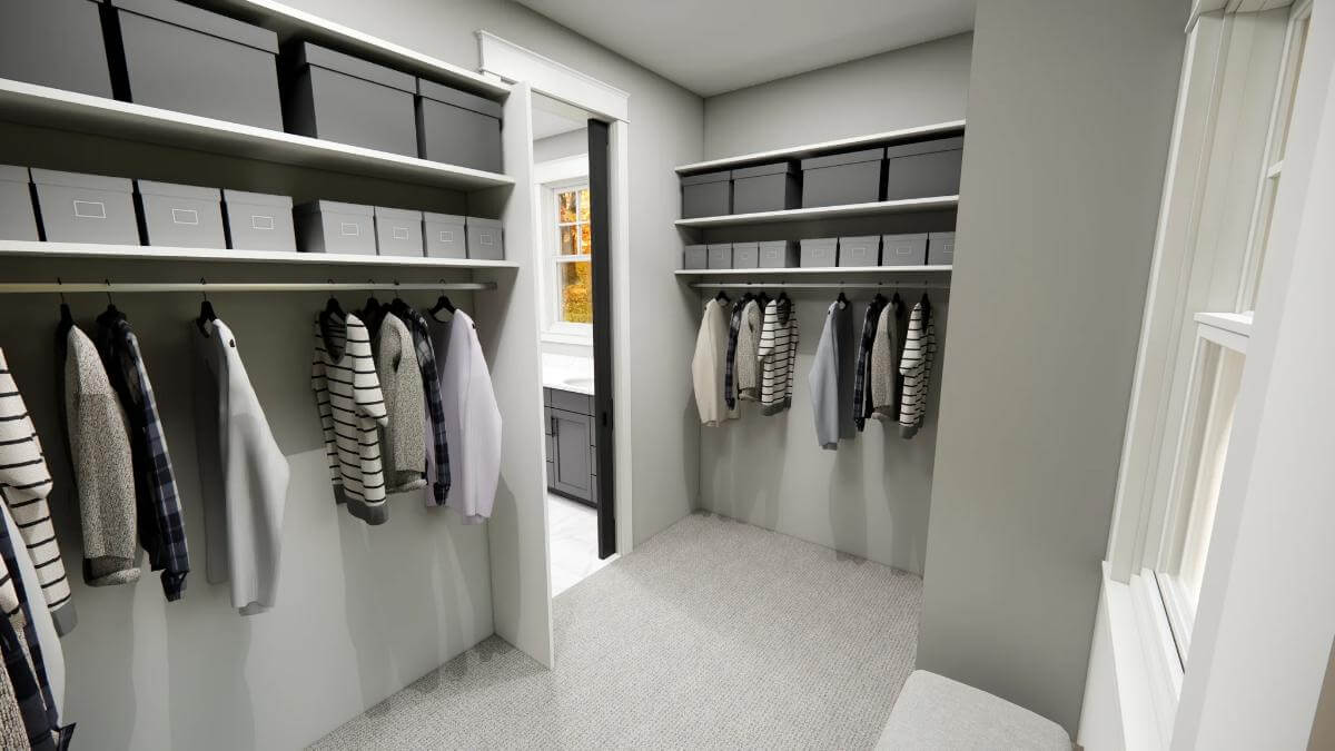 Primary walk-in closet with built-in shelves and a carpeted floor.